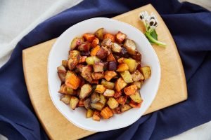 Eat more veggies. Overhead shot of roasted sweet potatoes in a white serving bowl.